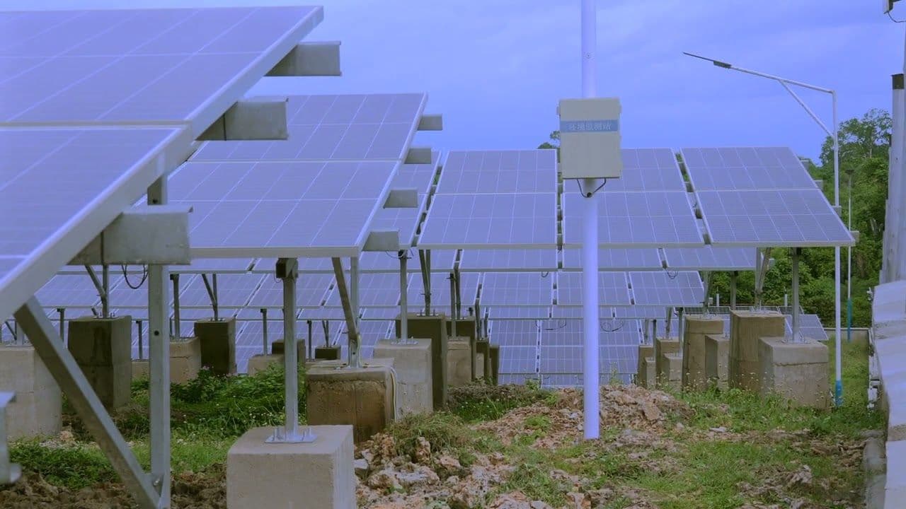 Rows of solar panels on a green hillside